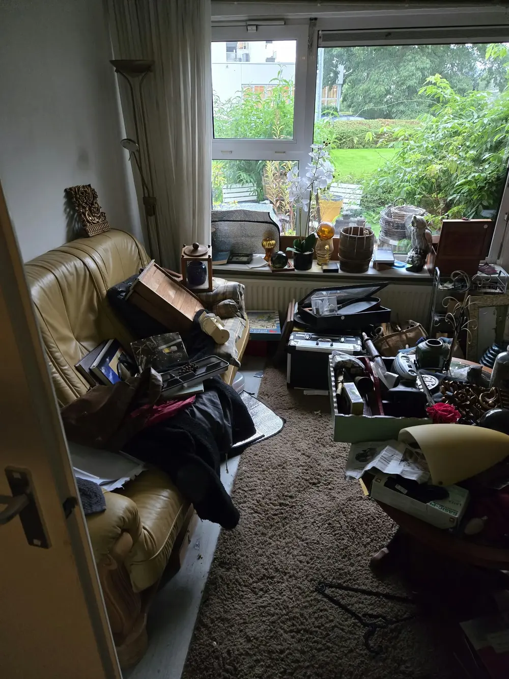 Woonkamer vol spullen voor de ontruiming door Woningontruiming Plus